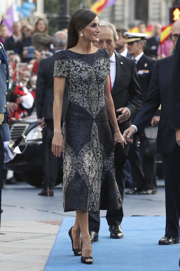 El pasado 19 de octubre de 2018  en los Premios Princesa de Asturias, la Reina  se superó a sí misma con un impresionante vestido midi en patchwork brocado y detalles joya bordados a mano en hilo, cristal y metal azul noche, cerúleo y pizarra que incluía un sutil toque rosa (¿un guiño, quizá, al Día Mundial contra el Cáncer de Mama?) firmado por Felipe Varela que estamos deseando verle de nuevo... quizá en algún viaje oficial.