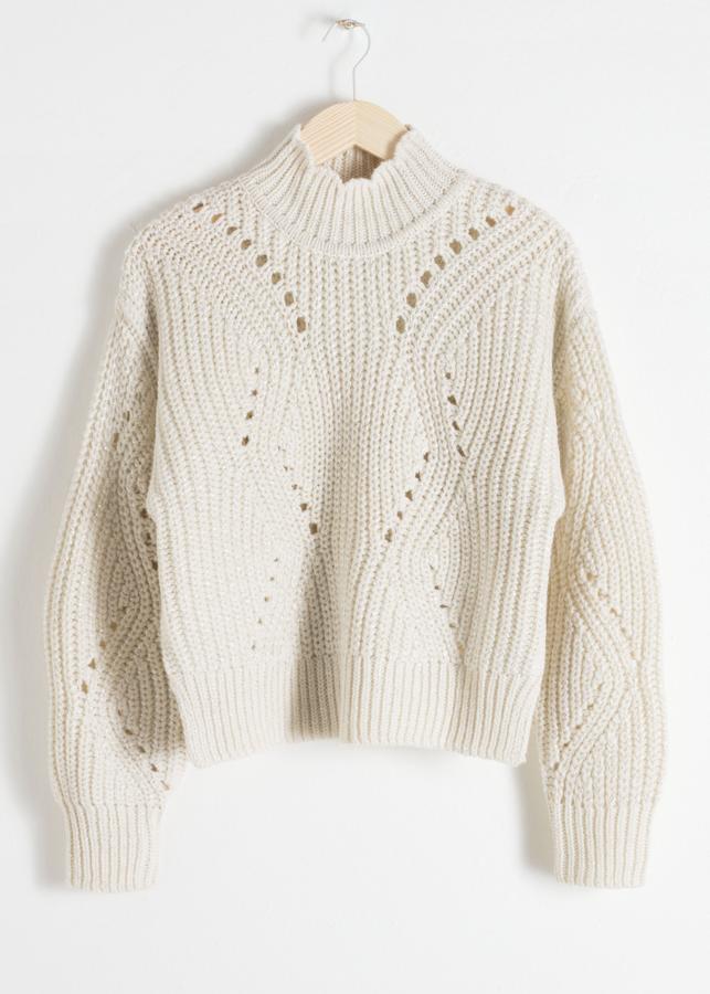 Preciosos diseño en colo blanco roto, con punto grueso que dibuja calados en todo el jersey (41 euros).