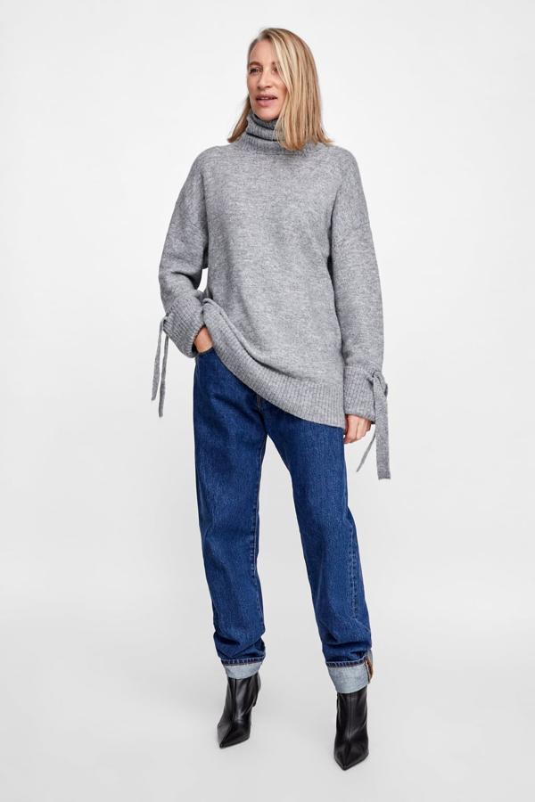 Jersey amplio de punto con cuello subido y detalle de lazos en los puños, 19,99 euros.