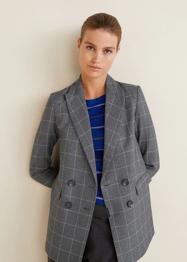 La blazer con estampado de cuadros pasa de 49.99 a 19.99 euros en las últimas rebajas de Mango.