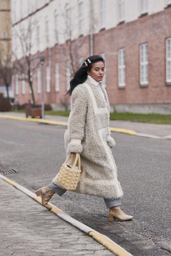 Las horquillas han invadido nuestro repertorio de accesorios pero es que, además, esta foto de "street style" esconde otra tendencia top: el bolso de perlitas. Si además sumamos el abrigo de pelo y la camisa blanca, nos sale el verdadero look que está triunfando desde ya.