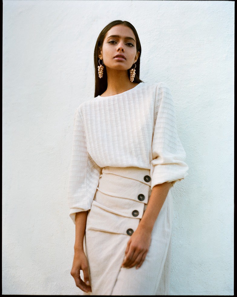 Uno de nuestros looks favoritos para la próxima temporada, basado en falda midi con botones y pendientes de cascada. 17,99 euros y 4,5 euros, respectivamente.