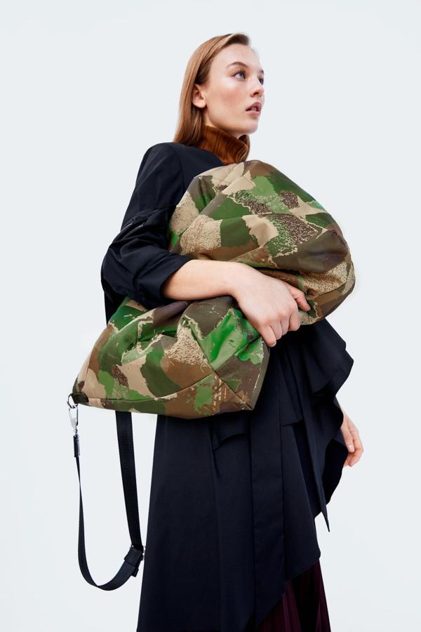 Bolso formato shopper con estampado de camuflaje, confeccionado en material acolchado. Lleva asas de mano y asa de hombro extensible y extraíbl, interior forrado con bolsillo y cierra con un imán (29,95 euros).