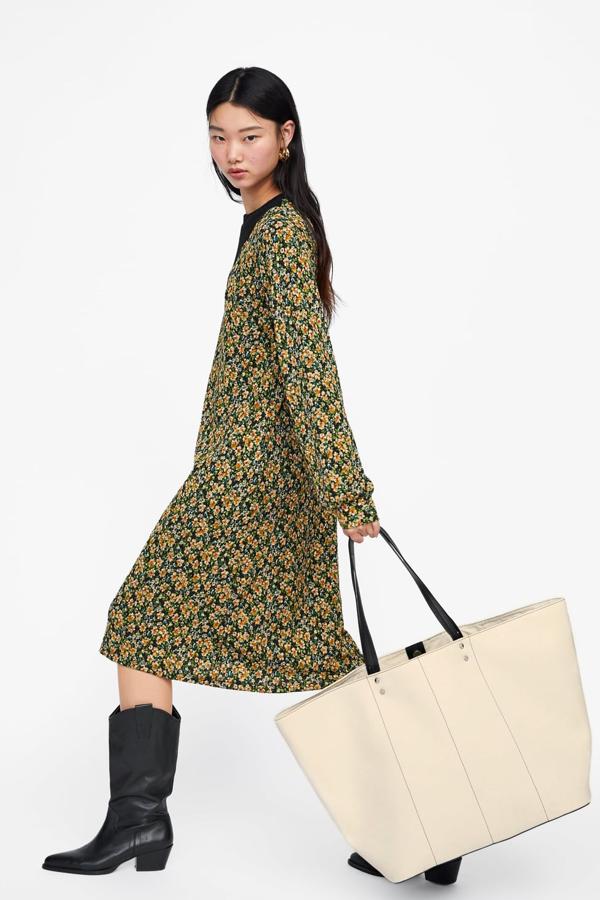 Shopper extragrande de color crudo, con pespuntes en el corte y asas de mano en contraste de color. Lleva un detalle de tachas en la parte superior y el interior forrado. Cierra mediante imán (35,95 euros).