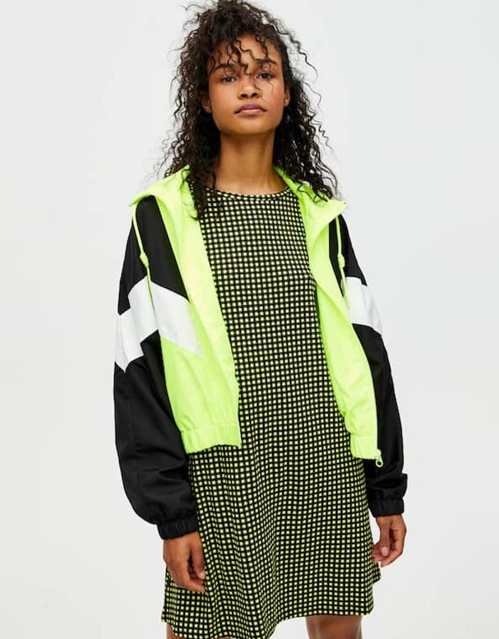 Vestido mini de manga corta, con un diseño fluido en crepé y cuello redondo (12,99 euros) y cazadora con diseño de paneles en diagonal en varios colores, cierre de cremallera y puños y bajo elástico (19,99 euros).