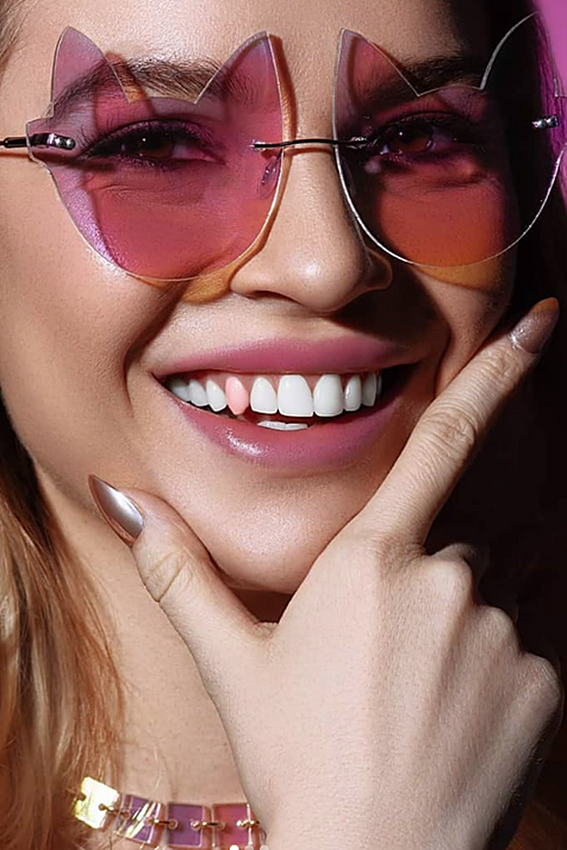 Detalle de un solo diente decorado con laca rosa.