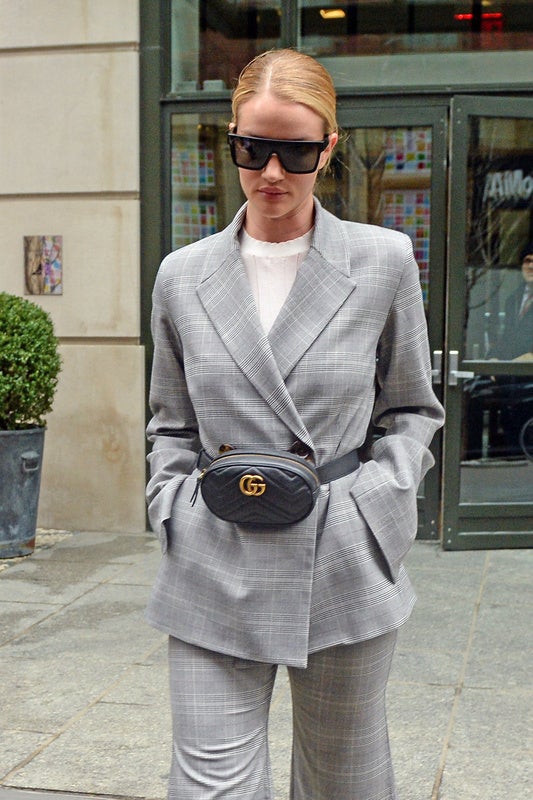 Rosie Huntington ha optado por un traje de chaqueta en color gris a cuadros, debajo una camisa blanca y el toque especial lo pone esta riñonera negra de Gucci, la firma por excelencia que hizo que las riñoneras se llevaran así.