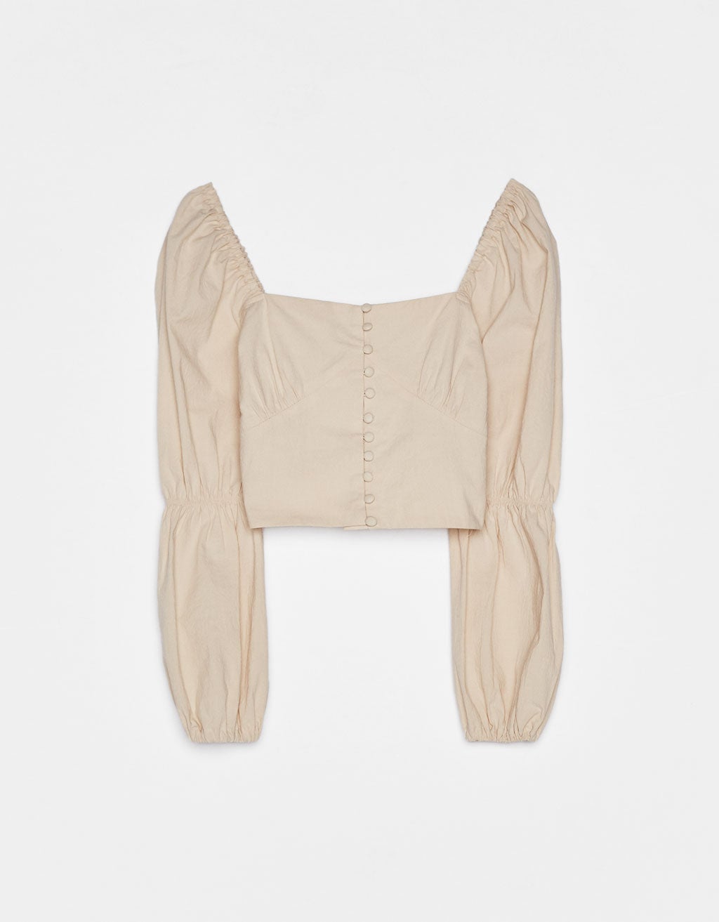 Blusa campesina color crudo de Bershka con mangas abullonadas y botones. (22,99 euros).