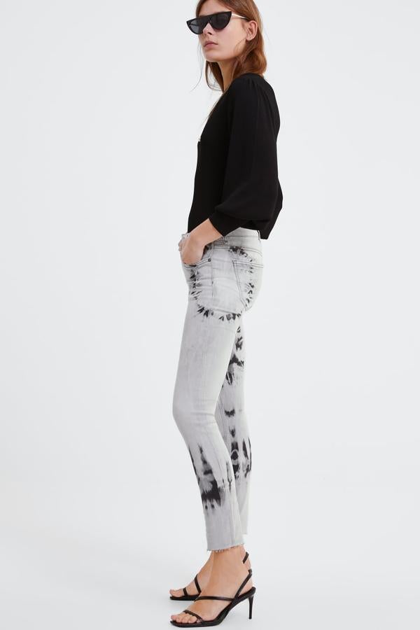 Jeans de tiro medio con cinco bolsillos y efecto desteñido. Lleva el bajo con un acabado deshilachado (29,95 euros).