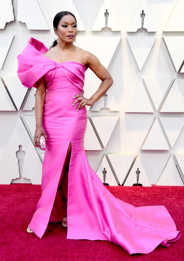 Angela Bassett con un vestido de Reem Acra. Un traje en tono fucsia con un hombro al descubierto y lazo XL.