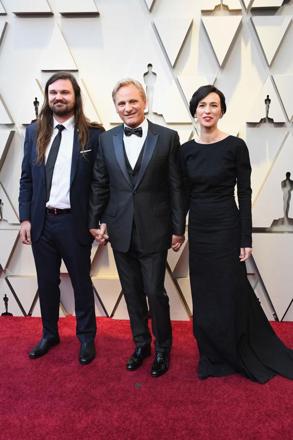 Ariadna Gil, acompañada de Viggo Mortensen en la alfombra roja de los Oscar 2019, con un elegante vestido negro de silueta minimalista de Cortana.