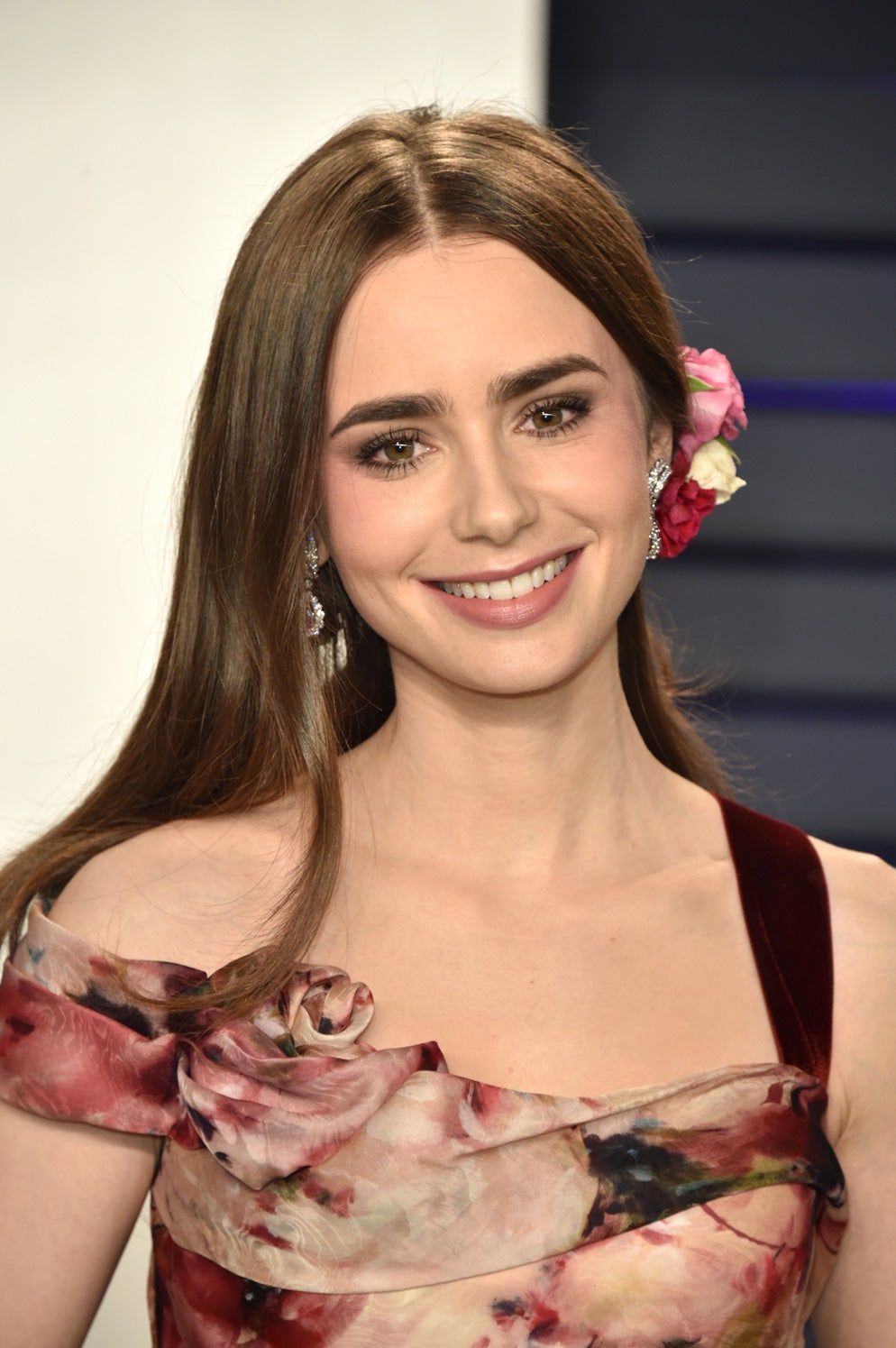 El maquillaje de Lilly Collins es perfecto para cuando quieres lucir tonos oscuros pero sin que lleguen a ser extremadamente llamativos. Labios y ojos muy difuminados y rebajados de color para un rostro aterciopelado y suavizado que rejuvenece.