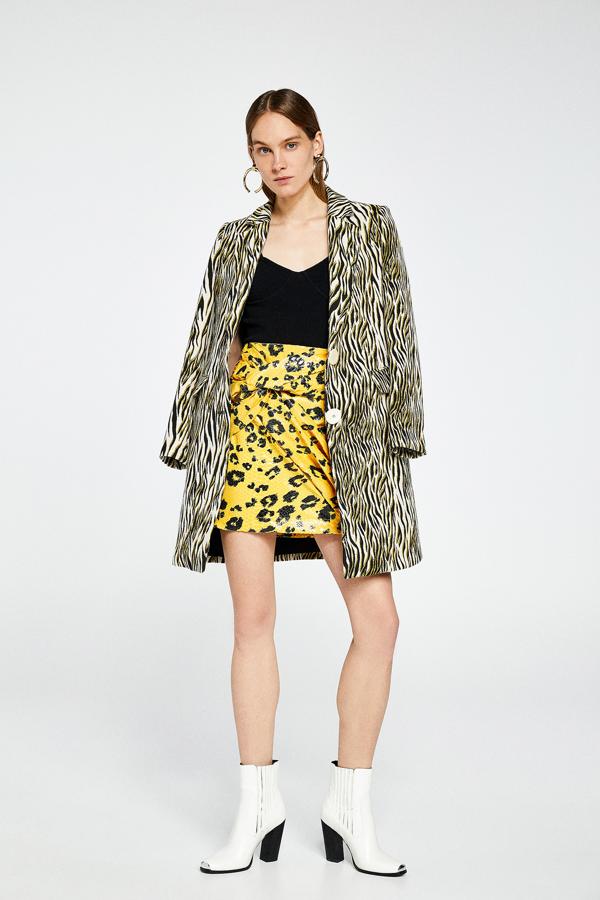 Sfera transforma los estampados de día en una prenda de noche poniéndoles lentejuelas. Es el caso de esta falda mini que, además, tiene el detalle del nudo. Su precio es de 35,99 euros.