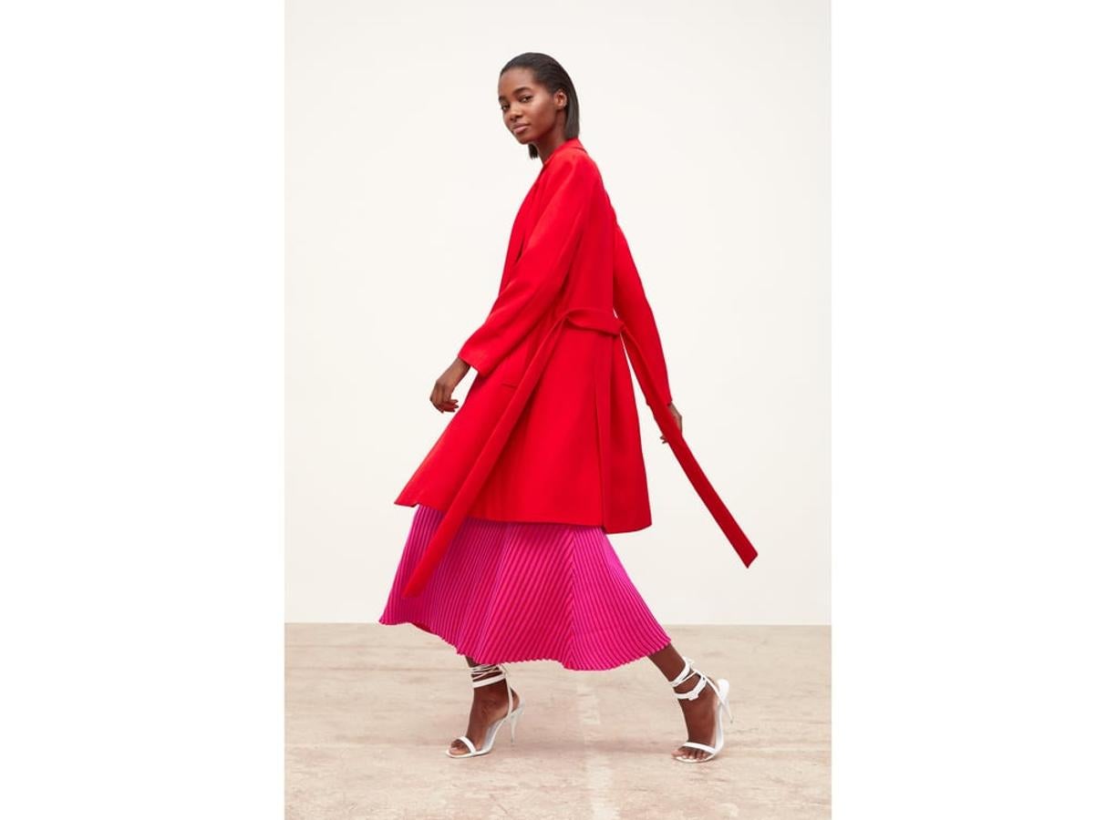 Zara nos propone la combinación rosa-rojo en looks tan femeninos como este, con una falda midi de canalé (25.95 euros) y un abrigo de entretiempo (69.95 euros).