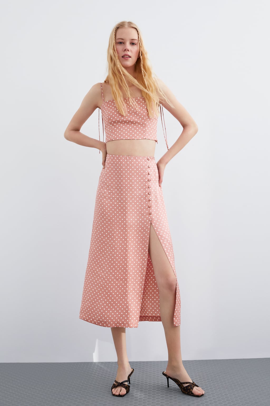 Los lunares han vuelto a invadir todas las prendas de Zara en todos los colores y tamaños. Conjunto de top y falda midi de Zara en rosa pastel. (19,95+22,95 euros).