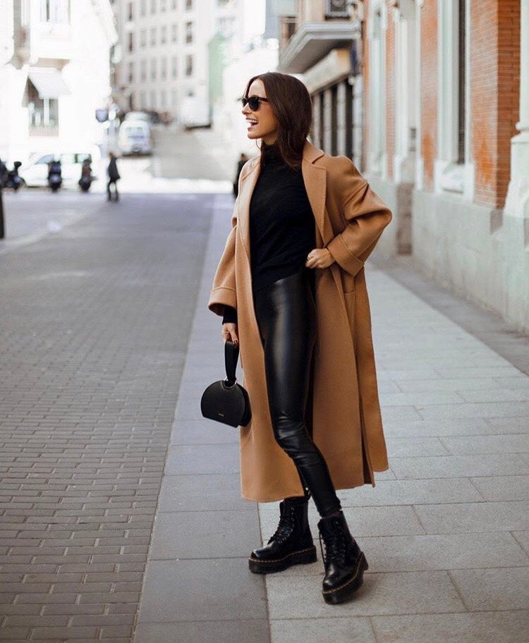 Total look negro con abrigo maxi en tono camel.