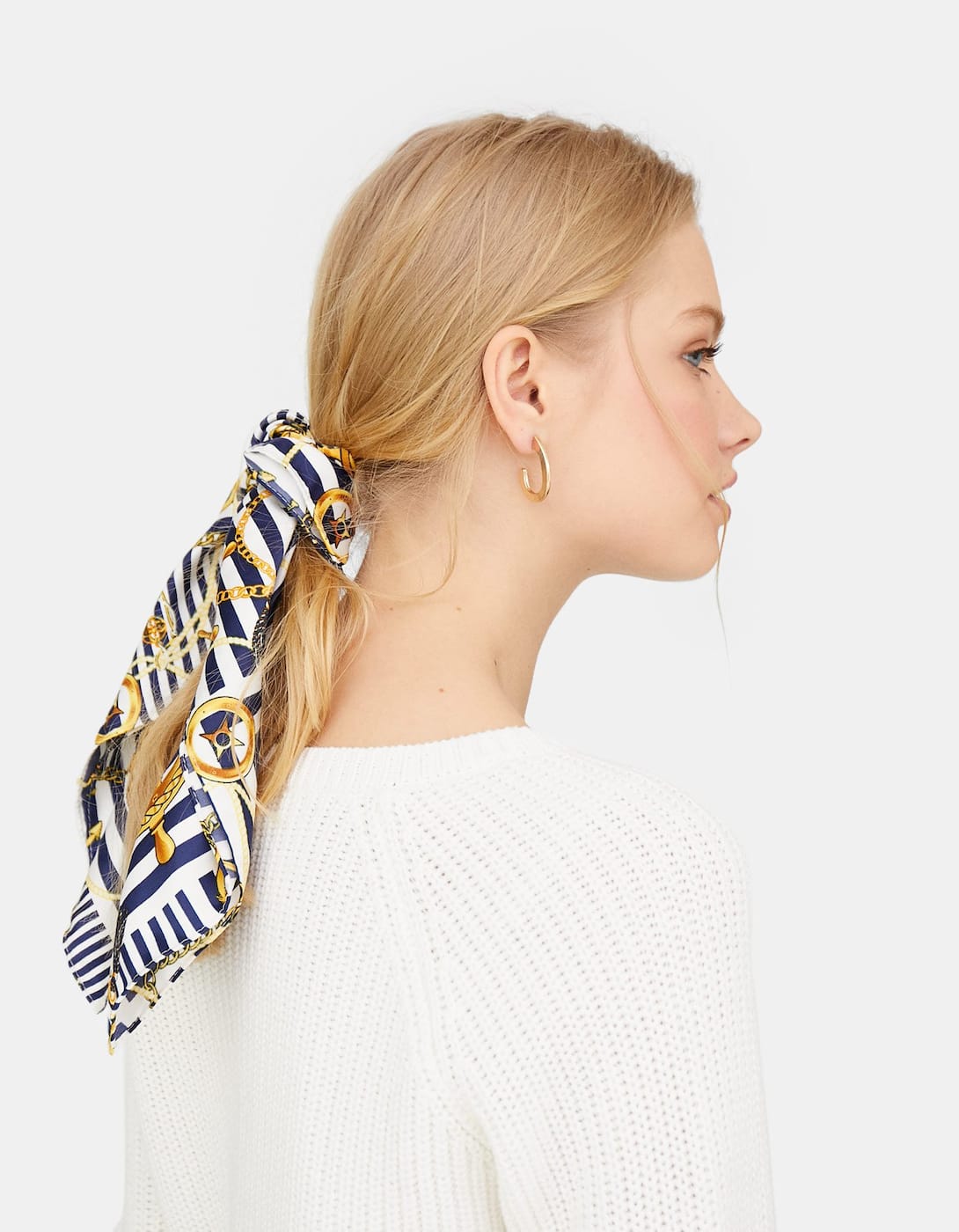 Un pañuelo para primavera puede ser el mejor accesorio que compres y este de cadenas es el más bonito de Stradivarius. Puedes usarlo tanto en el cuello como en el pelo para decorar tus peinados favoritos. (5,99 euros).