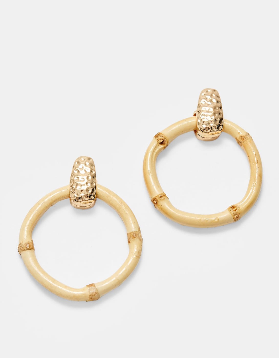 Los tonos crema, crudos y beige son tendencia entre los accesorios low cost. Ficha estos pendientes de aro que imitan al bambú y triunfa esta primavera. (7,99 euros).