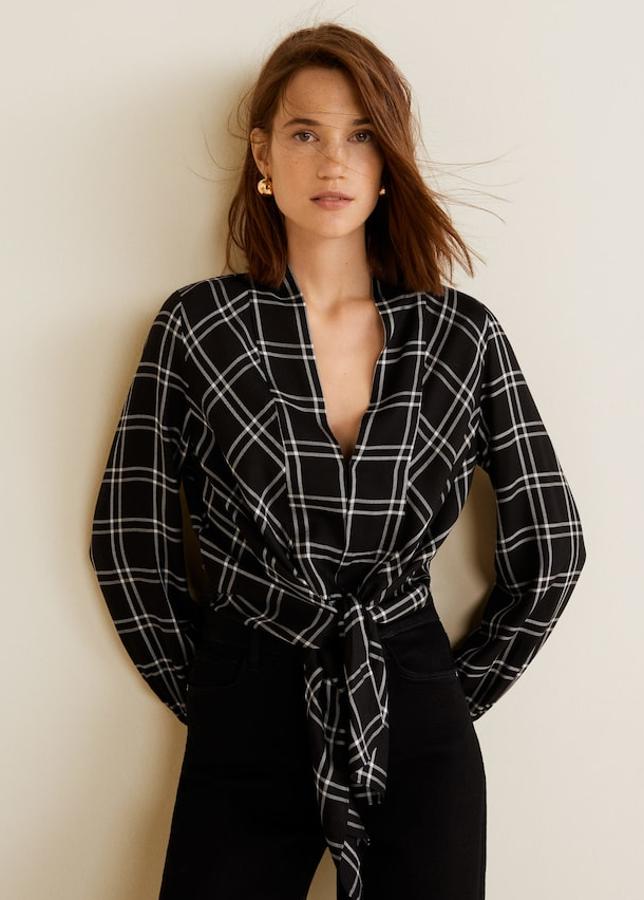 Lleva un cuello clásico y escote de pico y cierra con botones y con un lazo. La manga larga está ligeramente abullonada (Mango, 19,99 euros).