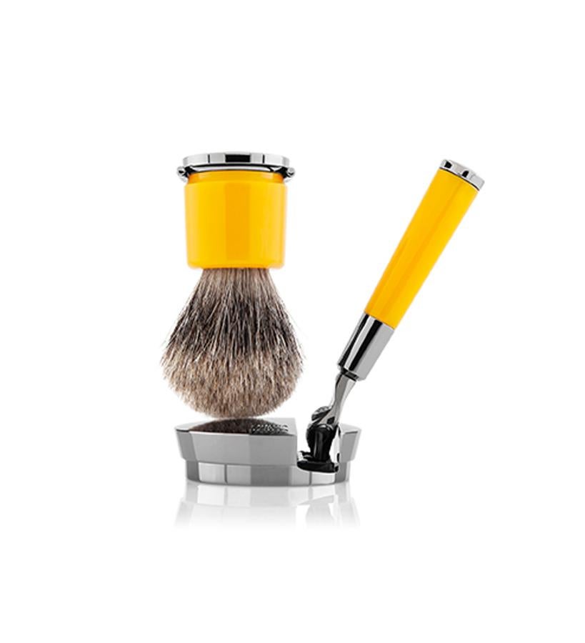 Este kit es el complemento perfecro para un afeitado de lujo. Está formado por La brocha, realizada con suave material sintético o con pelos de tejón, está hecha a mano en Italia. La maquinilla distribuye del peso en el fondo de la base para permitir una empuñadura firme y así conseguir mayor precisión.  Deluxe Stand Amarillo de la colección Barberie de Acqua di Parma  (490 €).