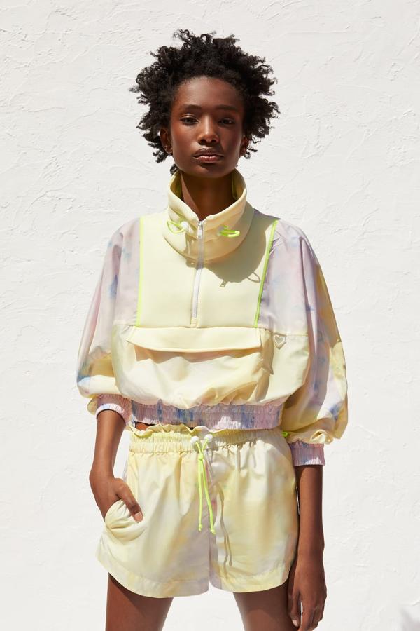 Fantástico mix de chubasquero corto y short de tiro alto, repelente al agua y bolsillos laterales (19,95 euros). El chubasquero lleva el cuello subido ajustable, manga larga acabada en elástico y bolsillo canguro. Cierra en el delantero con una cremallera (29,95 euros).