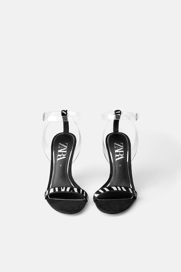 Sandalias de tira con estampado de cebra y detalle de pulsera al tobillo en vinilo transparente, de Zara (39.95 euros).
