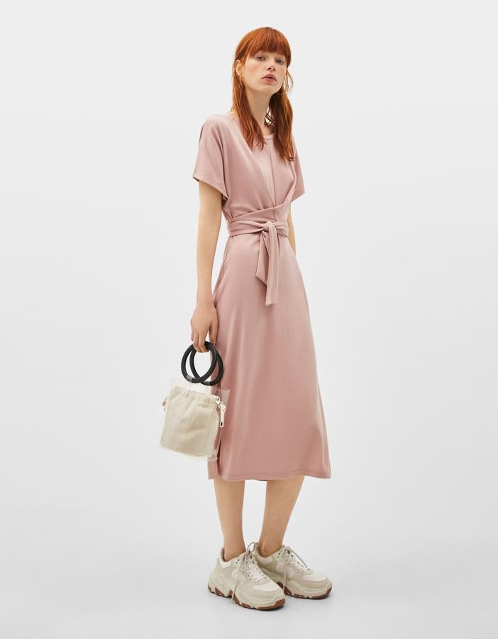 Vestido midi en punto rosa palo con detalle de cinturón cruzado, de Bershka (19.99 euros).