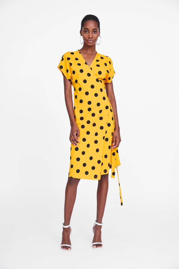 Vestido midi de silueta 'wrap' con estampado de lunares sobre fondo amarillo, de Zara (19.95 euros).