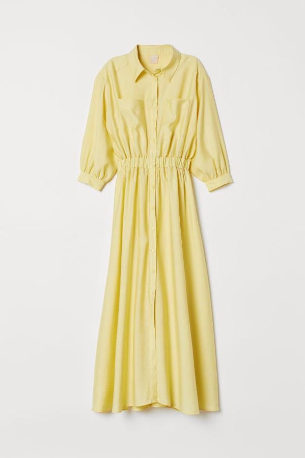 Vestido vaporoso en mezcla de viscosa con cuello, botones y canesú en la espalda. El diseño lleva los hombros ligeramente caídos, mangas tres cuartos holgadas con botón en los puños, bolsillos superiores, elástico revestido en la cintura y falda con ligero vuelo. Es largo hasta las pantorrillas y va sin forrar (59,99 euros).