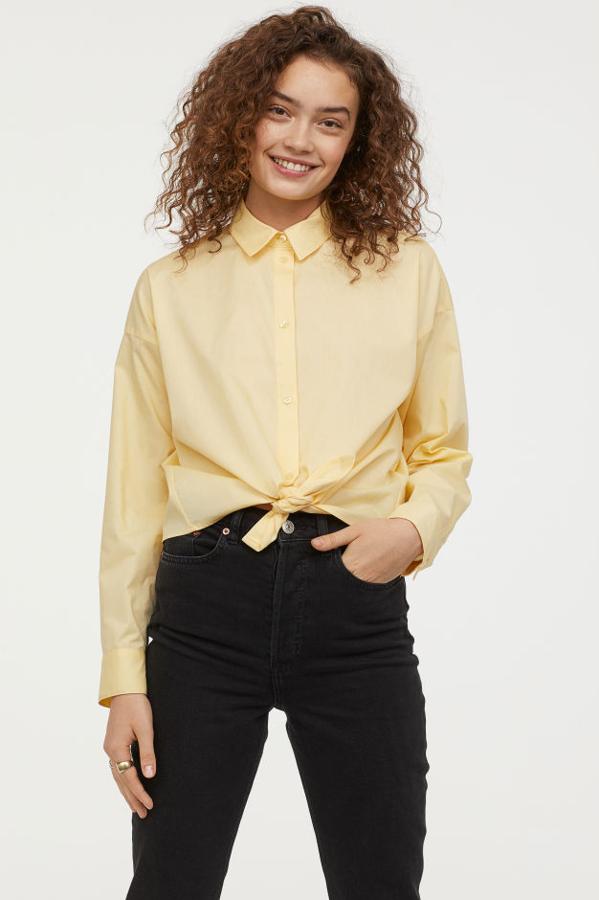 Camisa de algodón con cuello, botones delante, canesú en la espalda, hombros caídos, mangas largas con botón en los puños y nudo decorativo en la parte delantera del bajo (29,99 euros).