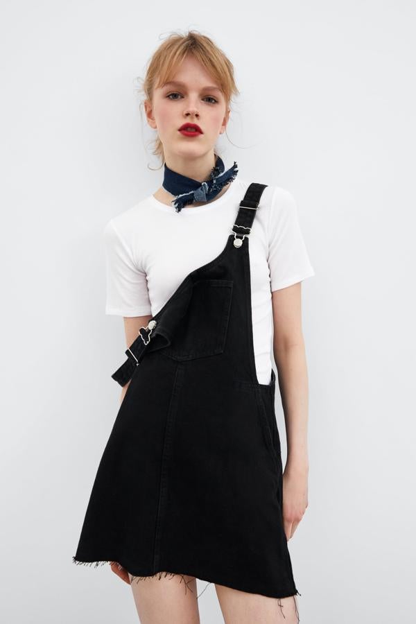 Con el bajo sin rematar para darle un aire más informal y en tejido vaquero negro, este peto de Zara es perfecto para estrenar ya (25,99 euros).