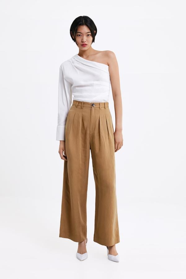 Nos encanta esta blusa blanca desestructurada con escote asimétrico (29.95 euros).