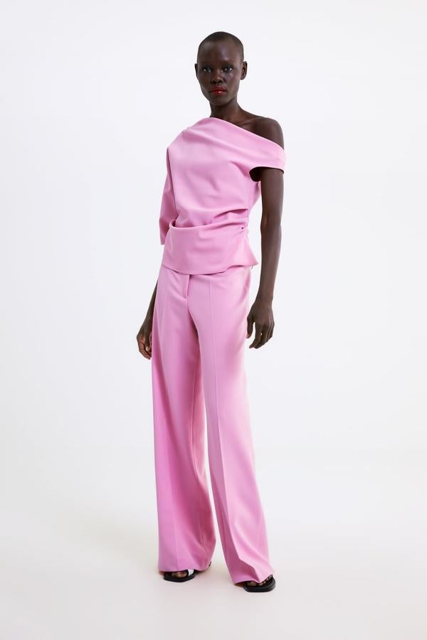 Cuerpo con cuello asimétrico de manga corta en color rosa claro (29,95 euros) a juego con unos pantalones rectos con bajo acampanado (35,95 euros).