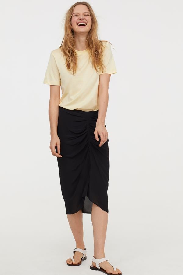 Un clásico que no falla para presumir de tipazo: falda lápiz negra con fruncido delantero de H&M (49.99 euros).