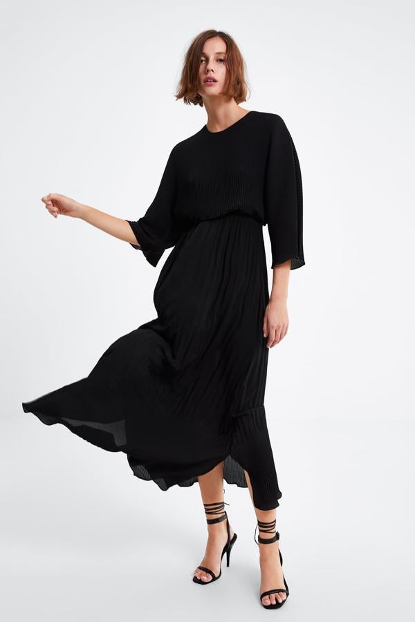 Vestido de cuello redondo y manga amplia por debajo del codo. Lleva la cintura elástica, forro y el bajo con aberturas laterales (Zara, 59,95 euros).