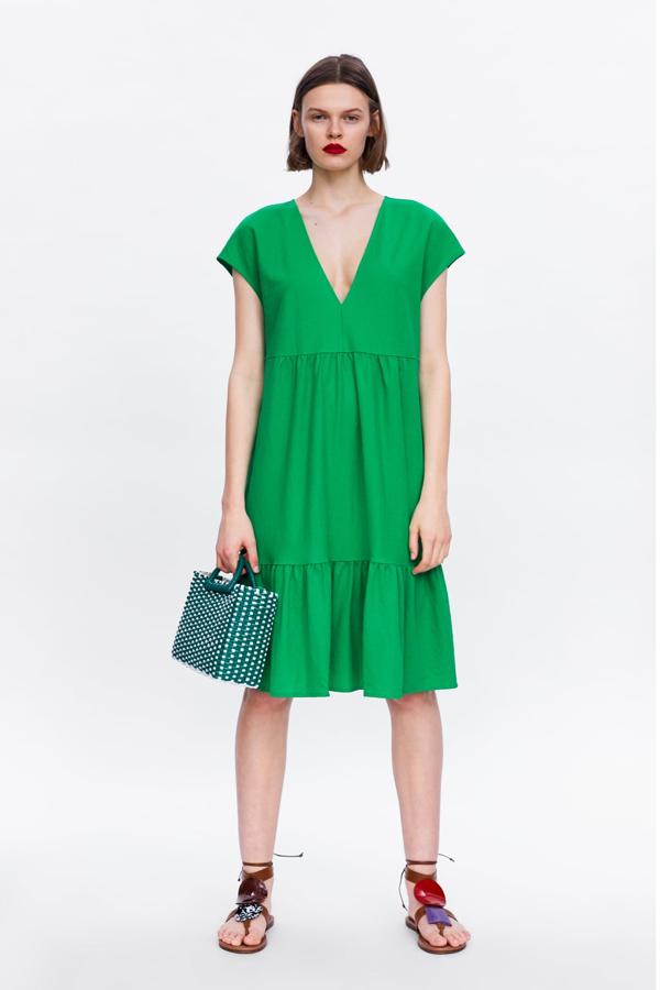 Vestido con escote en pico, manga corta y bajo con volante en color verde, 19,95 euros.