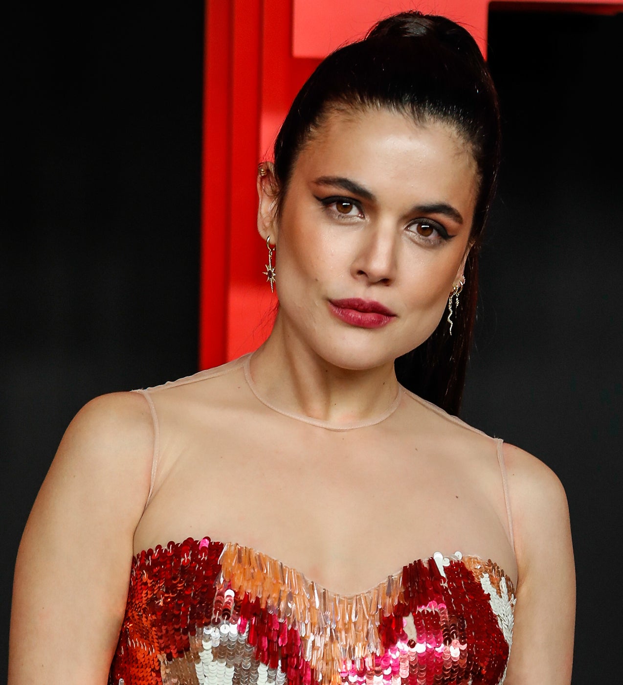 Hace tiempo que el maquillaje rojo dejó de utilizarse exclusivamente en los labios. Adriana lo ha plasmado sobre su boca y ojos para que hiciera juego con las lentejuelas de su vestido. Un eyeliner de largo casi infinito añade un poco más de sensualidad a un look que se completa con un sencillo moño de bailarina.