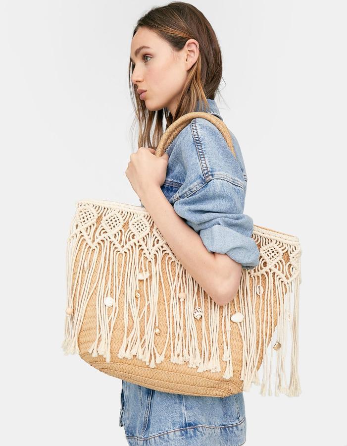 Versión "shopping bag", con flecos de los que cuelgan conchas y caracolas, este bolso es de Stradivarius (29,99 euros).