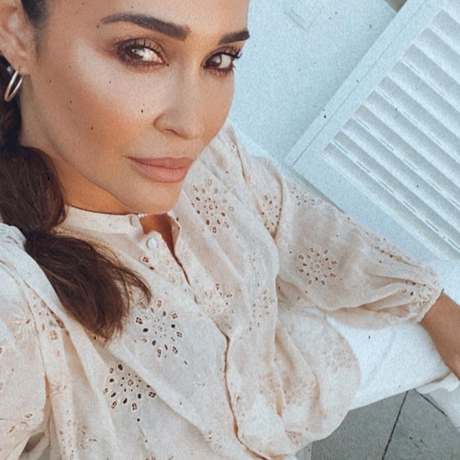 Los pantalones blancos son uno de sus básicos de verano. En este caso los combina con una blusa de calados de las rebajas de Zara. Los pantalones también tienen descuento.