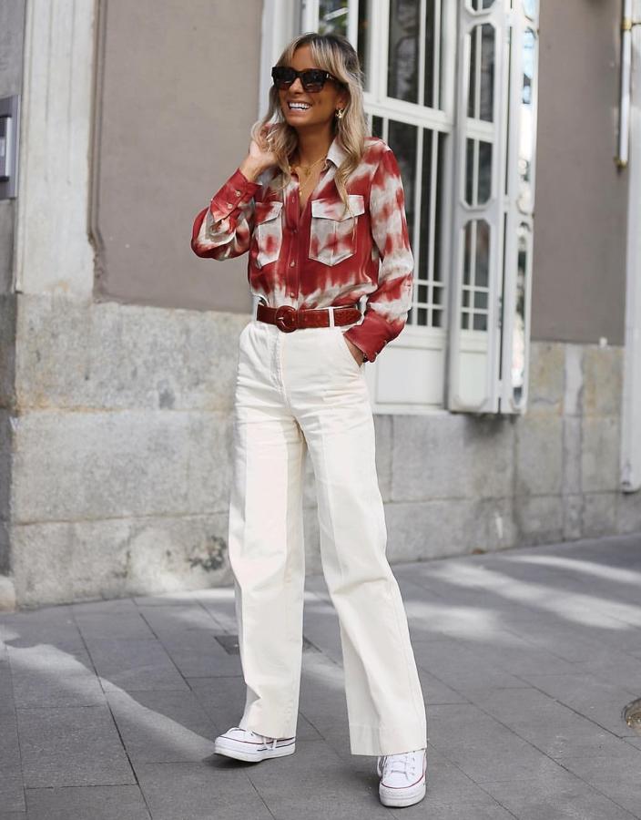 Paula Argüelles sabe que la tendencia Tie-Die es una de las más fuertes de la temporada, por eso no ha dudado en combinar esta camisa con ese tipo de estampado con unos pantalones denim de pata de elefante y sus inseparables Converse.