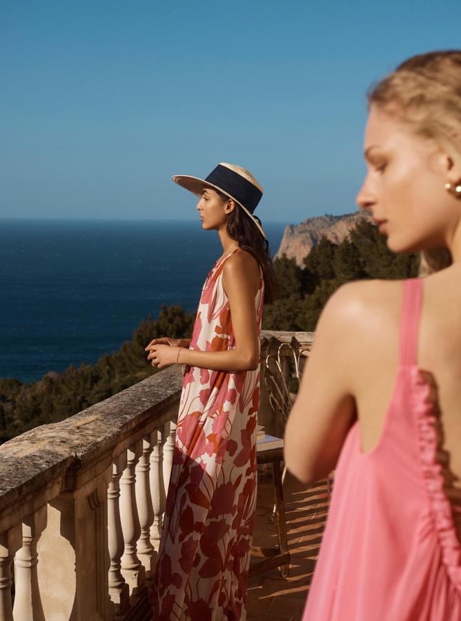 El maxi vestido fluido con estampado floral en fusia sobre fondo blanco cuesta 69.99 euros en Mango.