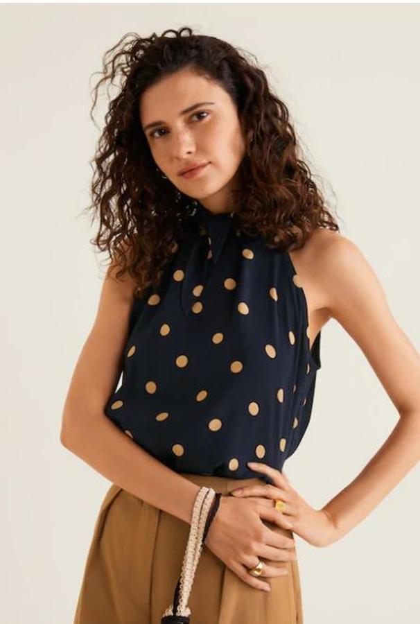 Sn mangas y anudado al cuello, la mezcla de colores beige y azul marino resulta de lo más elegante. Debajo de una blazer será tu mejor aliado para los looks de oficina esta primavera. Cuesta 19,99 euros.
