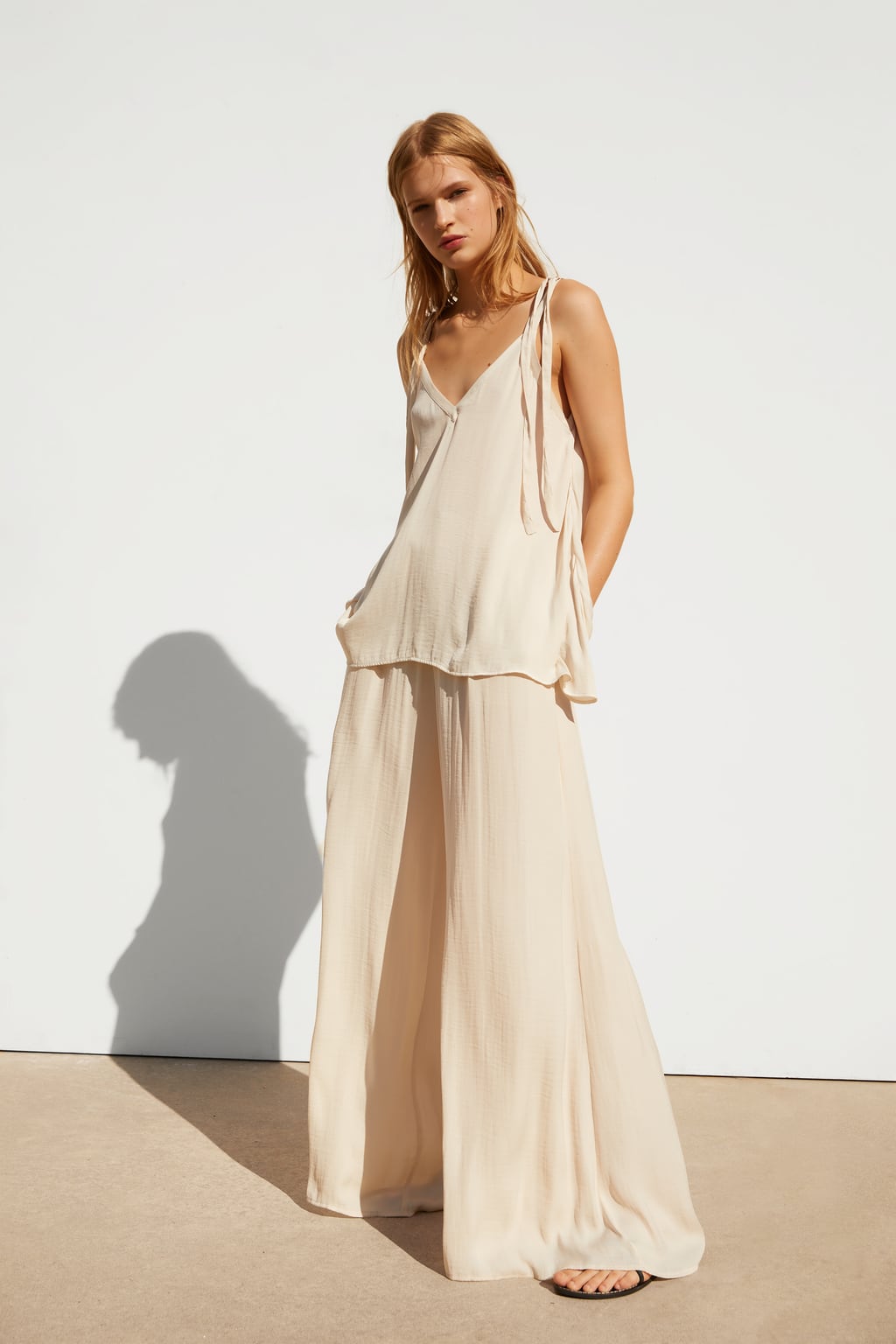 Incluso los pantalones más elegantes pueden quedar perfectos con unas sandalias planas este verano tal y como demuestra Zara con este look. (22,95 euros).