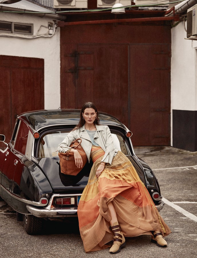Cazadora de Green Coast en El Corte Inglés, blusa y falda de Alberta Ferretti. Pendientes pulsera y anillos de Pandora. Bolso de Tod's y botines de Loewe. El coche es un modelo DS Tiburón.