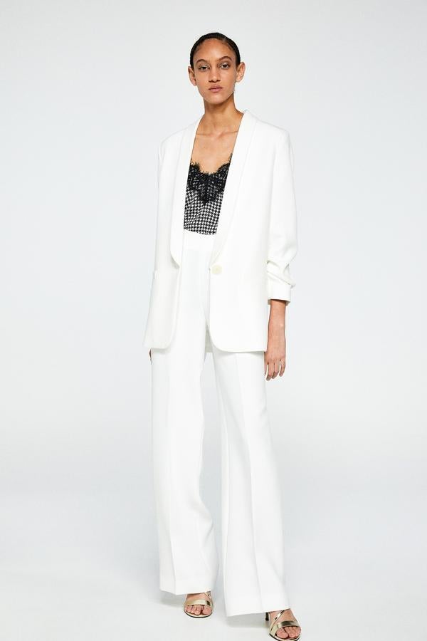 Una de las mejores copias 'low cost' que hemos encontrado del traje blanco de Carolina Herrera de la Reina es este dos piezas de Sfera: la chaqueta cuesta 45.99 euros; y los pantalones, 35.99 euros.