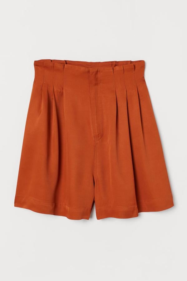 Pantalón corto en sarga de viscosa con el talle alto, pliegues cosidos, discretos bolsillos en las costuras laterales y cierre con cremallera oculta (H&M, 39,99 euros).