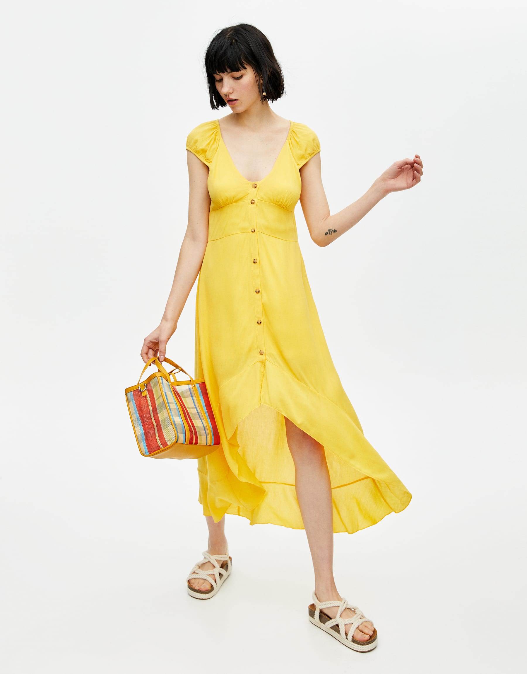 Este modelo de Pull&Bear es sin duda el más similar al vestido amarillo de Paula Echevarría por el corte, los botones y las mangas. Y sí, está disponible en todas las tallas. (29,99 euros).