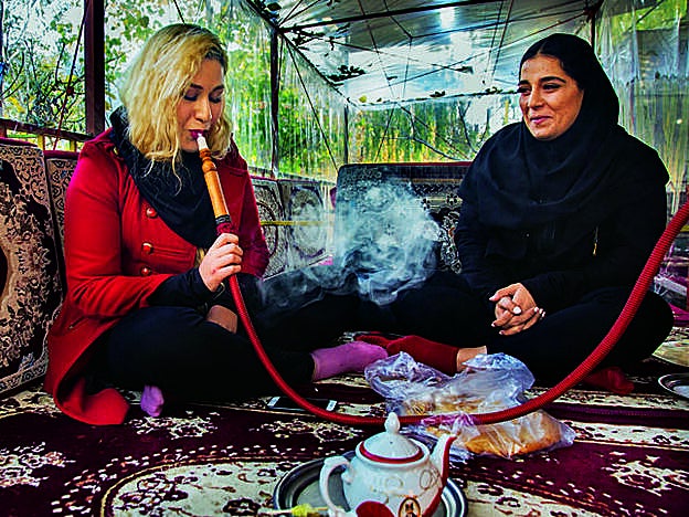 Juria (izq.) y Negar, ambas de 20 años y estudiantes de Ingeniería, fuman un narguile en la montaña Darband.