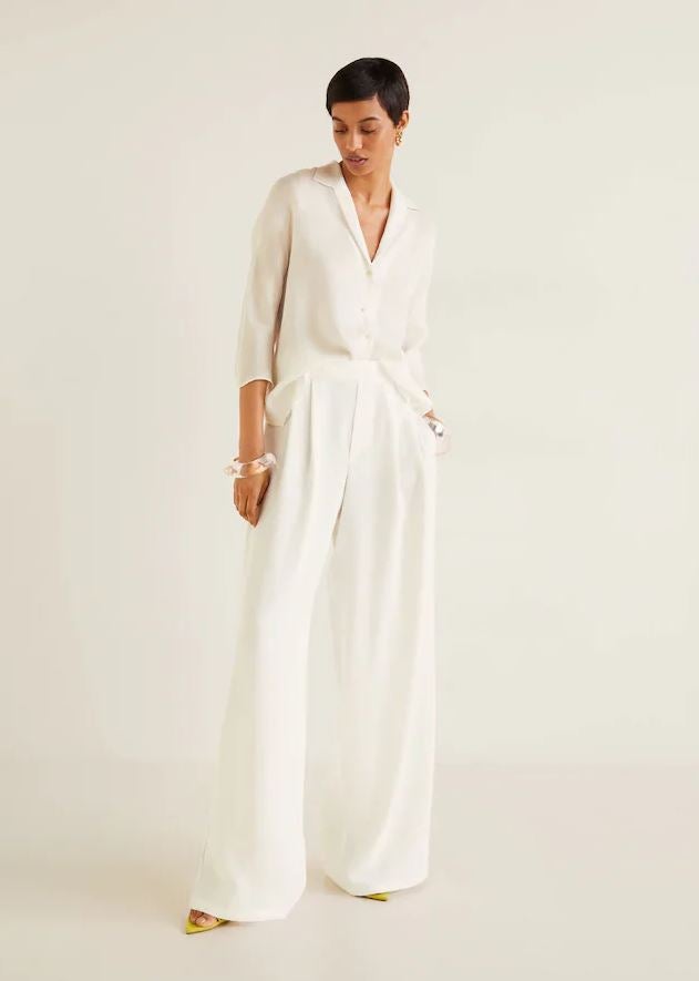 Pantalones palazzo blancos con pinzas de Mango (49.99 euros).