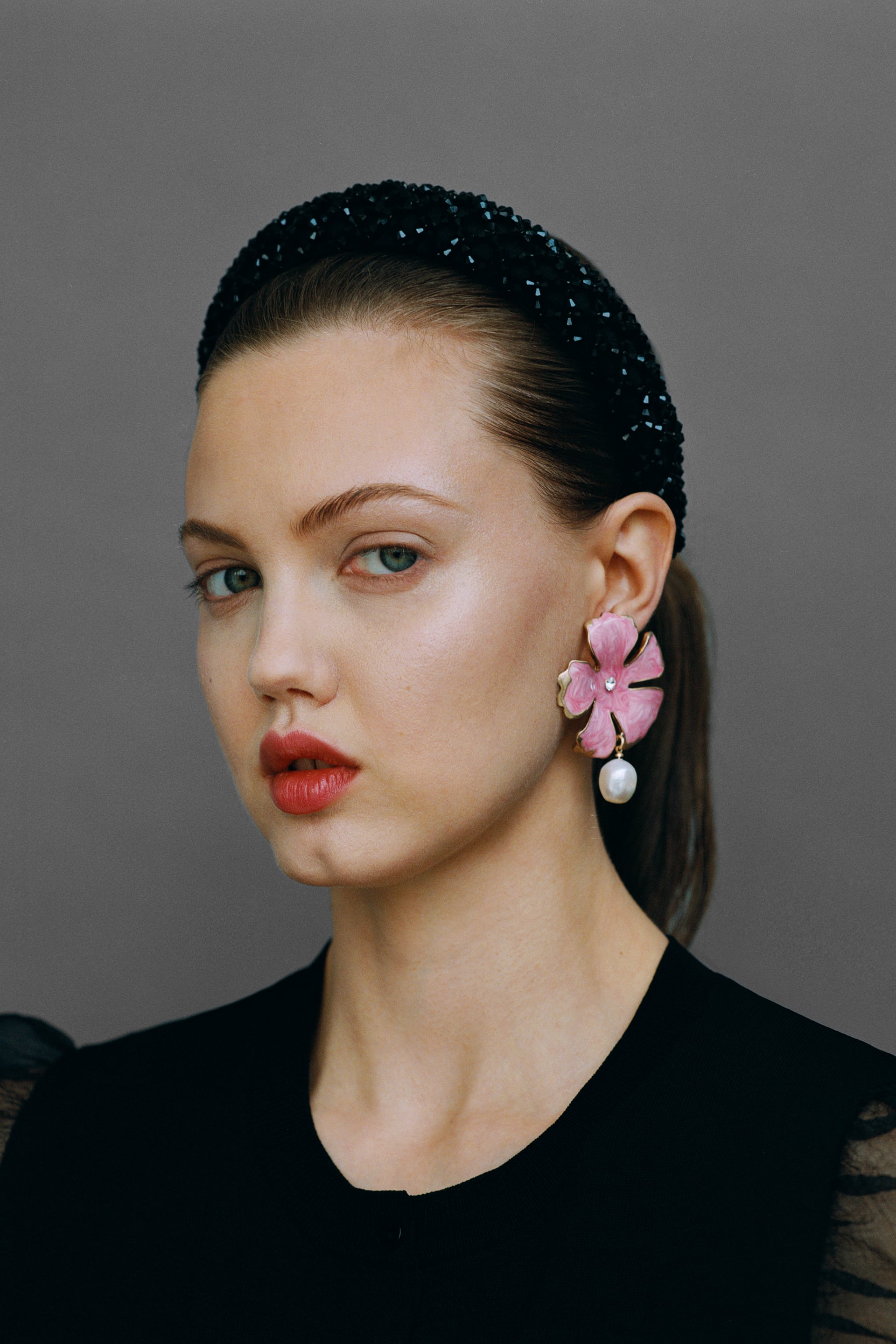 Diadema joya en negro (12.95 euros en Zara) y maxi pendientes de flor con perla (15.95 euros)